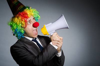 Clown in Satire mit Megaphone