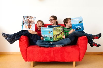 Kinder lesen Was ist Was Bücher auf der Couch. 