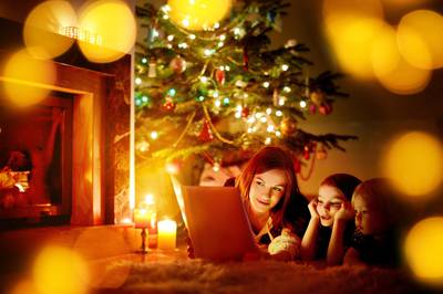 Familie liest Weihnachtsbücher unter dem Weihnachtsbaum